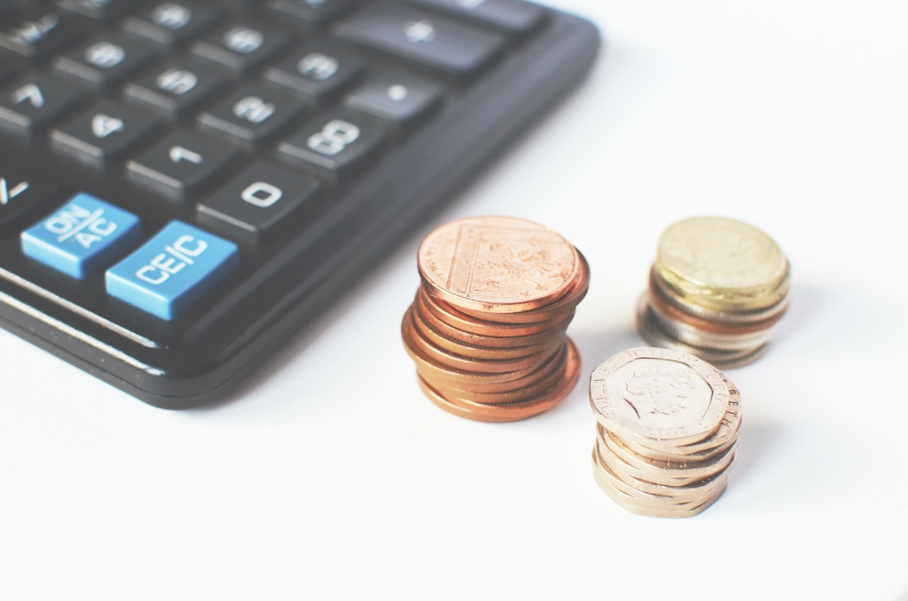 kalkulator i monety leżące na stole