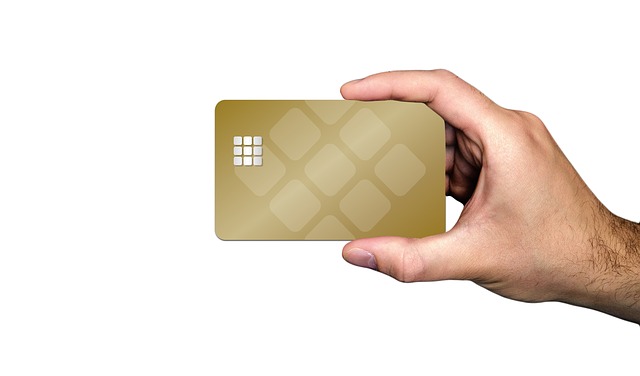 Mężczyzna trzyma w dłoni zlotą kartę kredytową