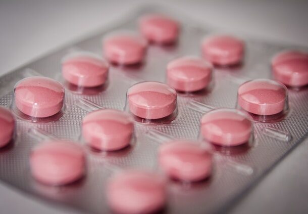 Różowe tabletki leża na stole w opakowaniu