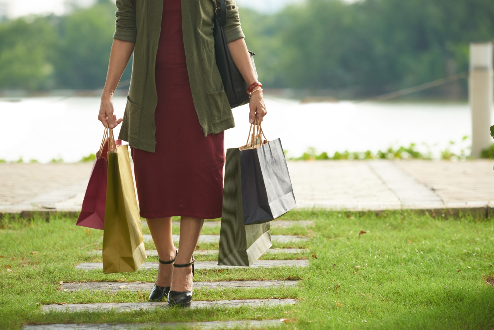 Kobieta wraca z zakupów trzymając w dłoniach torby na zakupy wielorazowe