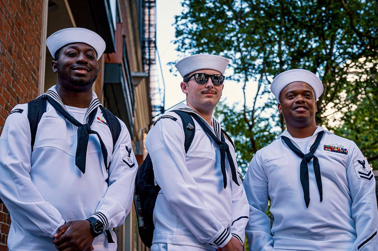 Trzech mężczyzn marynarzy stoi w mundurach obok siebie